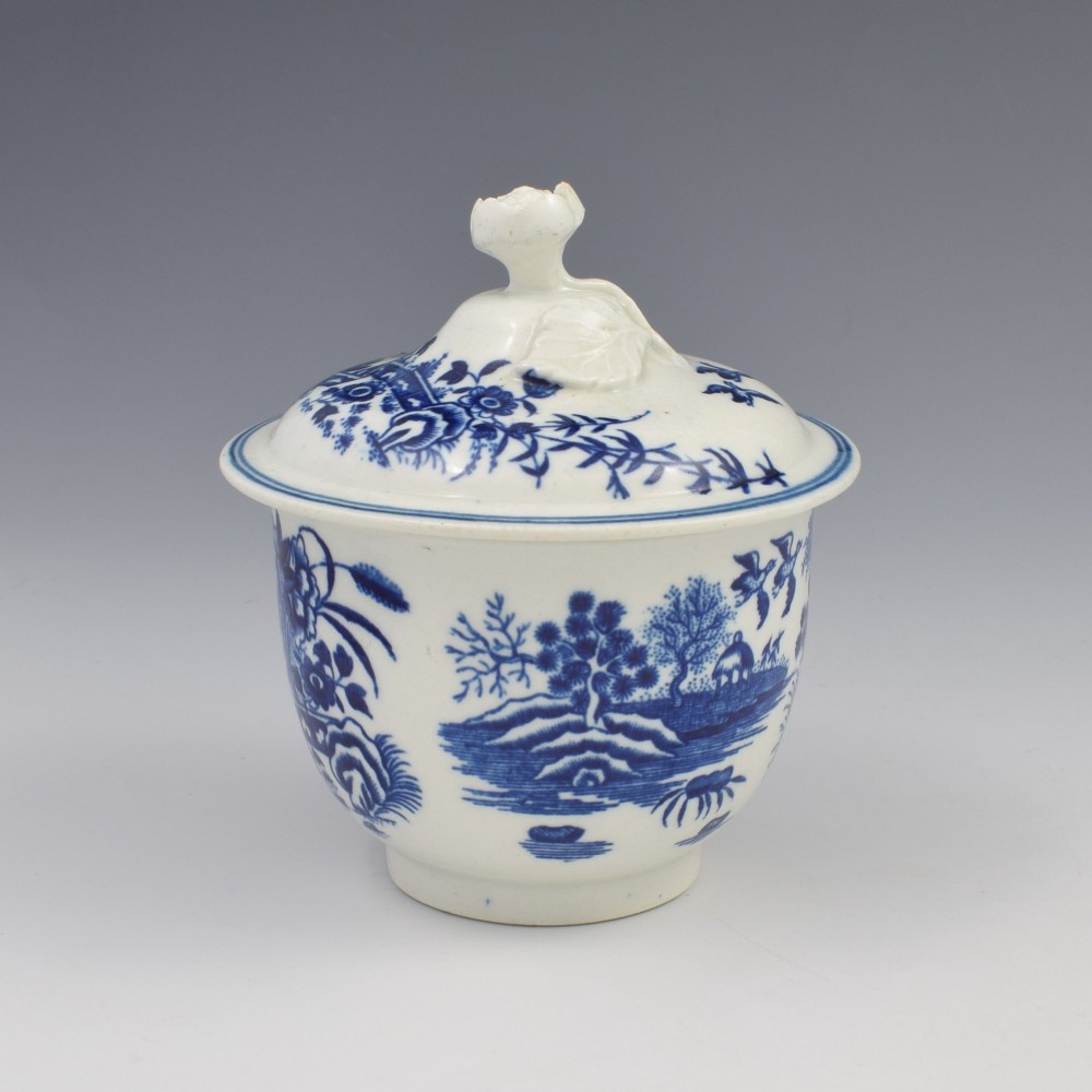 An 18th-century First Period Worcester soft-paste porcelain sucrier featuring an underglaze blue transfer-printed Fence pattern with a domed cover topped by a sculpted floral finial. View III