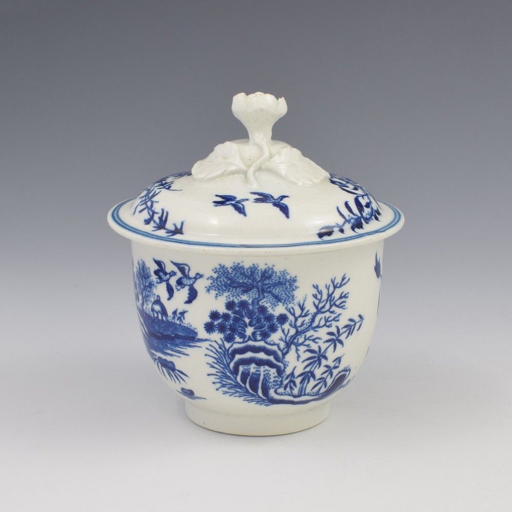 An 18th-century First Period Worcester soft-paste porcelain sucrier featuring an underglaze blue transfer-printed Fence pattern with a domed cover topped by a sculpted floral finial. View IV