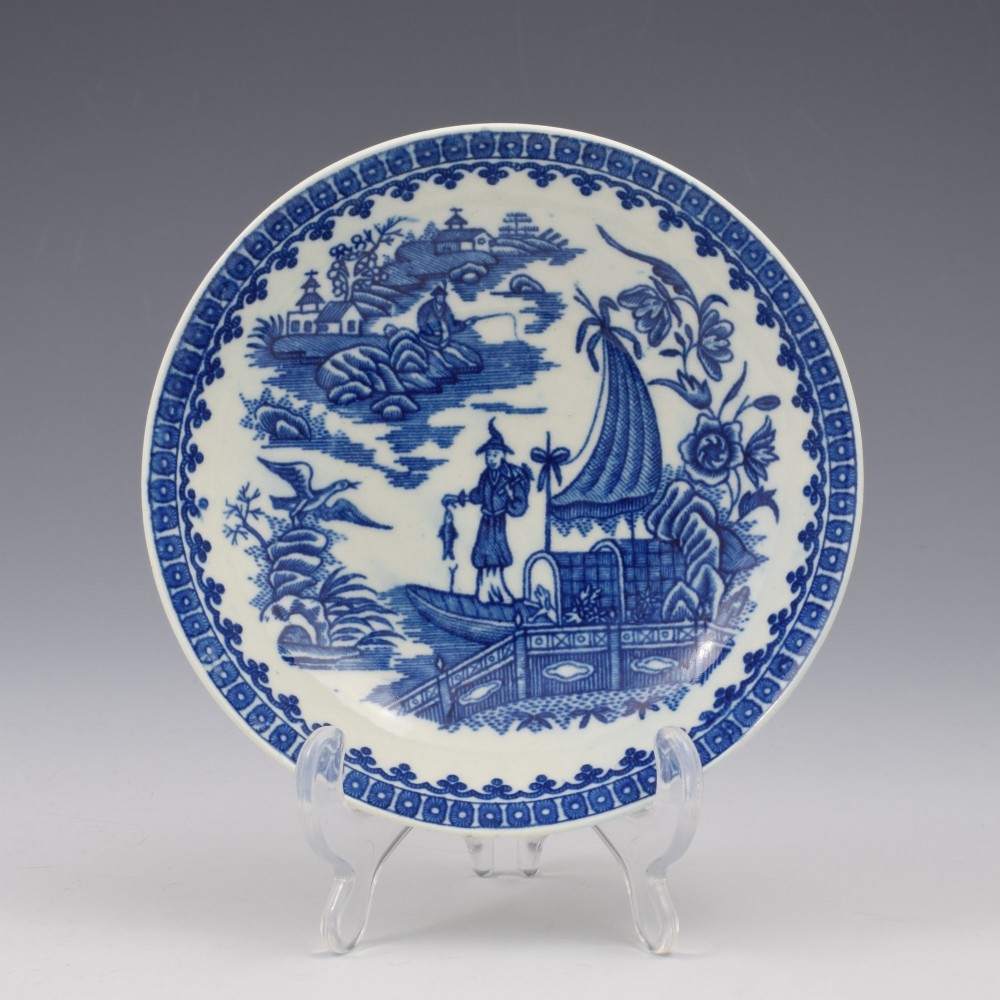 An 18th-century First Period Worcester porcelain tea bowl and saucer set featuring blue underglaze transfer-printed Chinoiserie fisherman patterns. View II