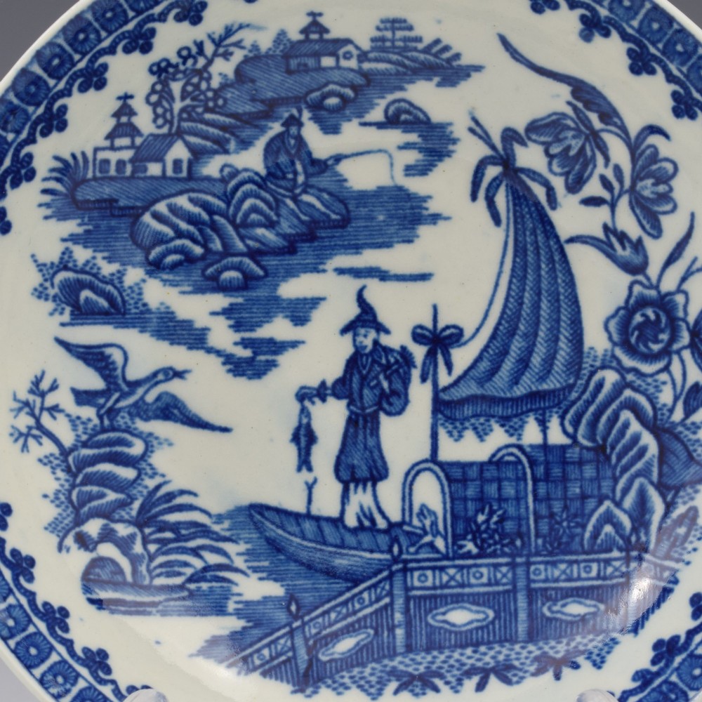 An 18th-century First Period Worcester porcelain tea bowl and saucer set featuring blue underglaze transfer-printed Chinoiserie fisherman patterns. View III