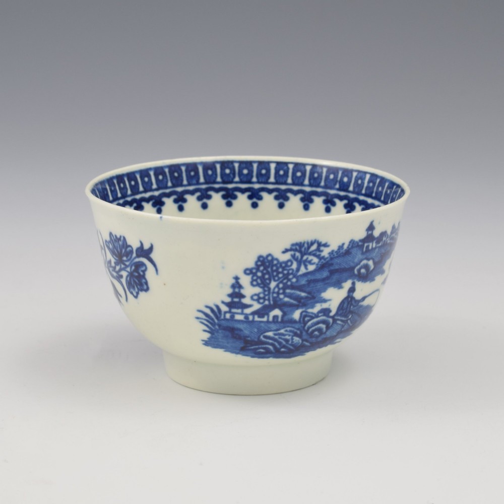 An 18th-century First Period Worcester porcelain tea bowl and saucer set featuring blue underglaze transfer-printed Chinoiserie fisherman patterns. View VI