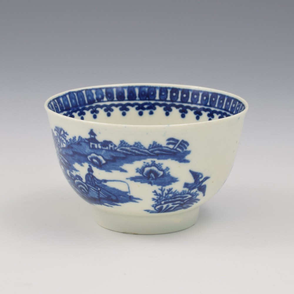 An 18th-century First Period Worcester porcelain tea bowl and saucer set featuring blue underglaze transfer-printed Chinoiserie fisherman patterns. View VII