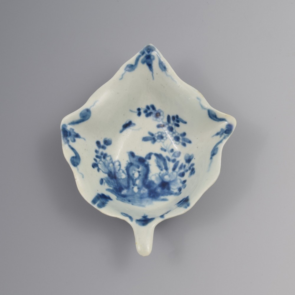 An 18th-century leaf-shaped soft-paste porcelain pickle dish featuring hand-painted chinoiserie motifs in underglaze blue.