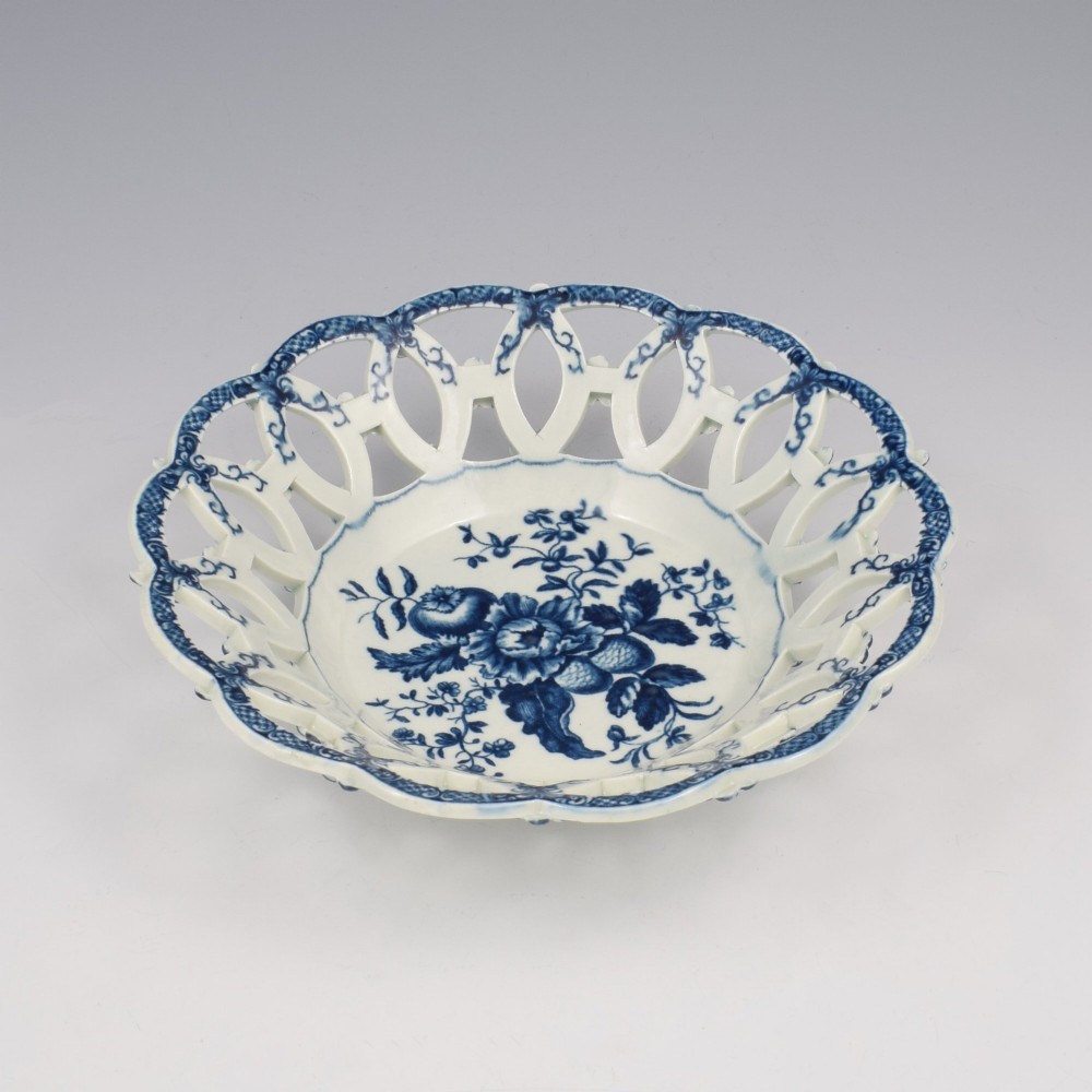 An 18th-century circular blue and white porcelain basket featuring a reticulated lattice rim and a central underglaze transfer print of flowers and pinecones. View III