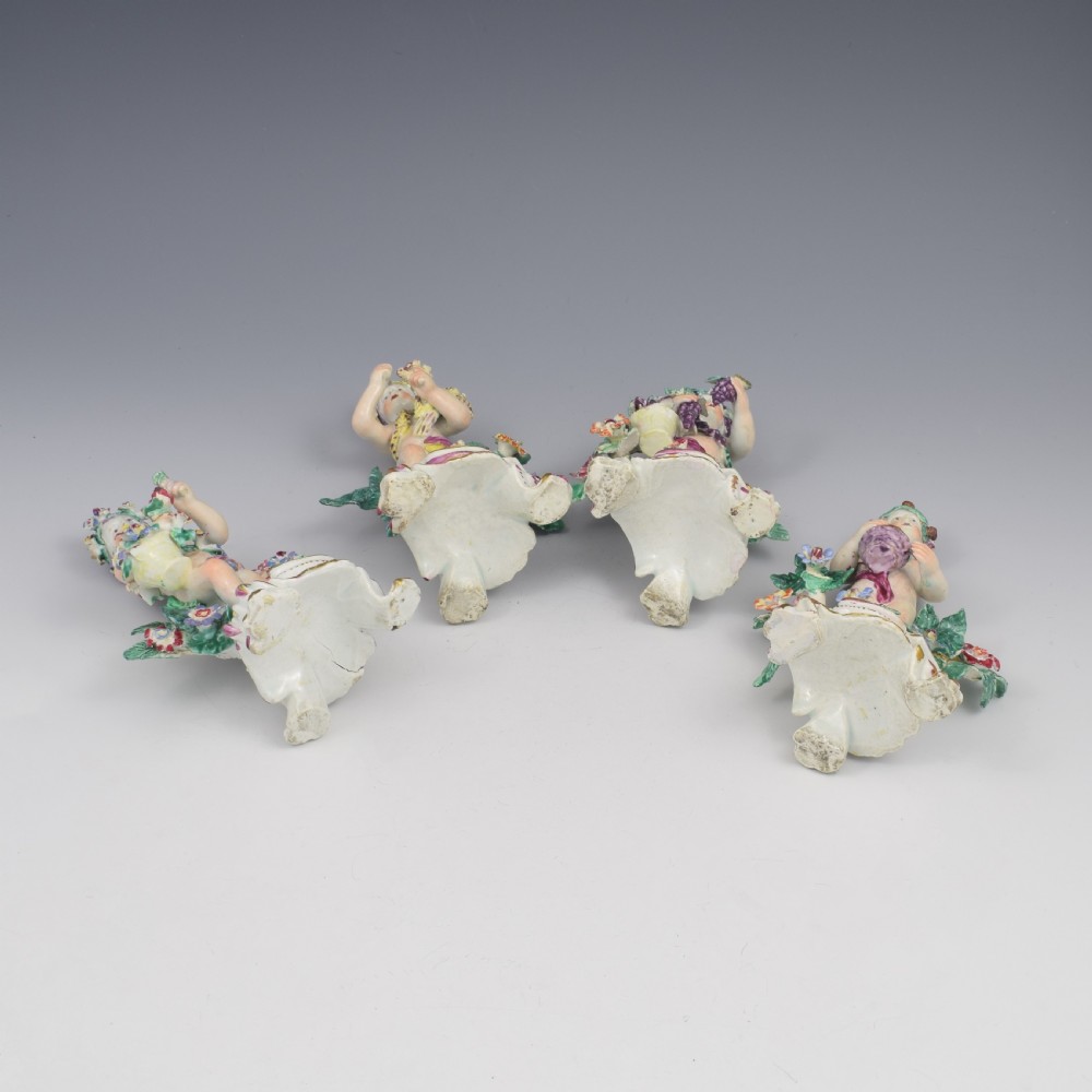 A set of four 18th-century Bow soft-paste porcelain figures representing the seasons, depicting putti on rococo scroll bases with colourful floral bocage. View XI