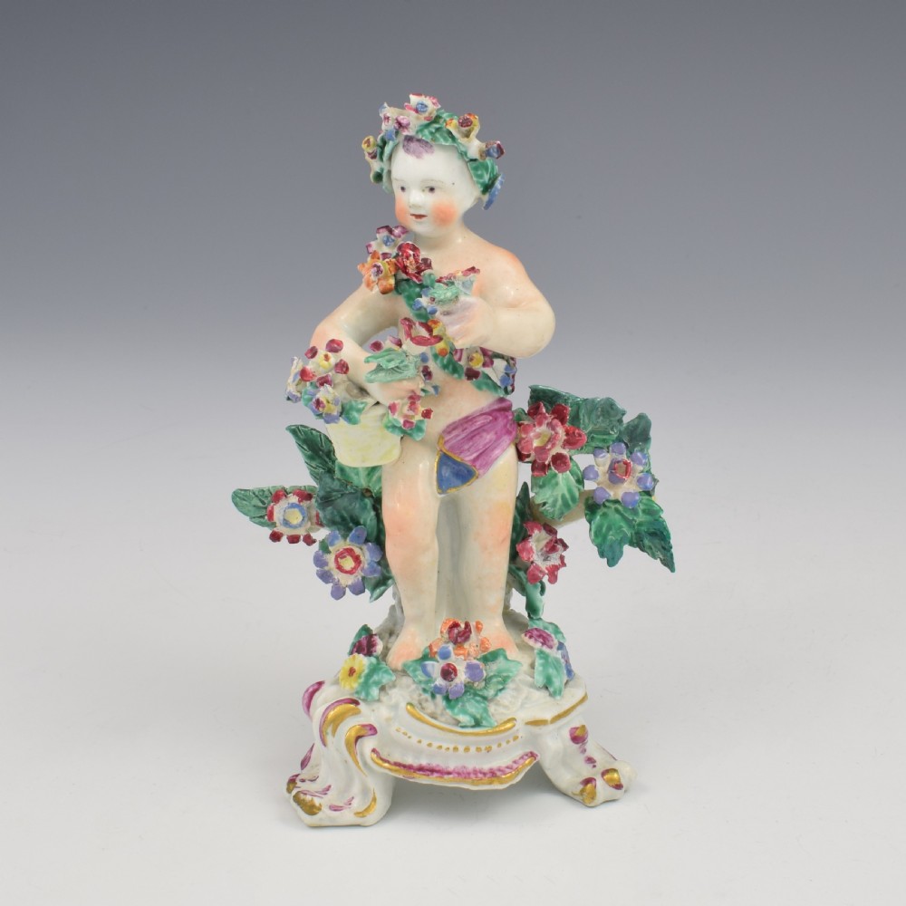 A set of four 18th-century Bow soft-paste porcelain figures representing the seasons, depicting putti on rococo scroll bases with colourful floral bocage. View XII