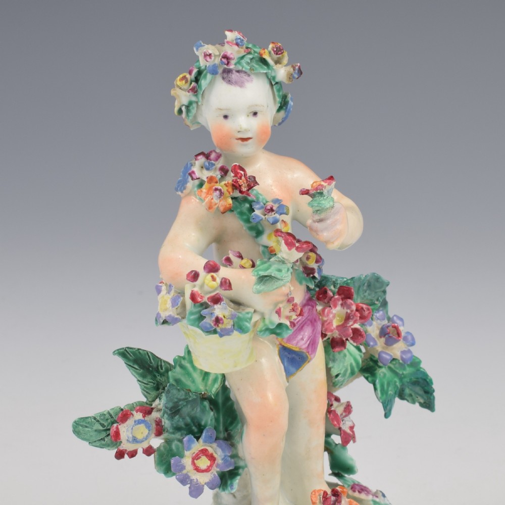 A set of four 18th-century Bow soft-paste porcelain figures representing the seasons, depicting putti on rococo scroll bases with colourful floral bocage. View XIII