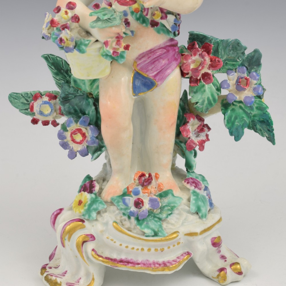 A set of four 18th-century Bow soft-paste porcelain figures representing the seasons, depicting putti on rococo scroll bases with colourful floral bocage. View XIV