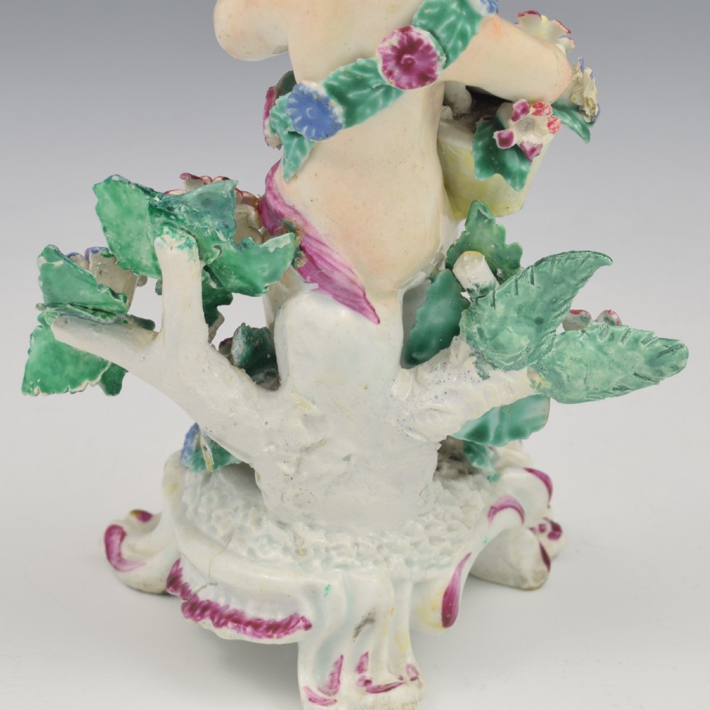 A set of four 18th-century Bow soft-paste porcelain figures representing the seasons, depicting putti on rococo scroll bases with colourful floral bocage. View XV