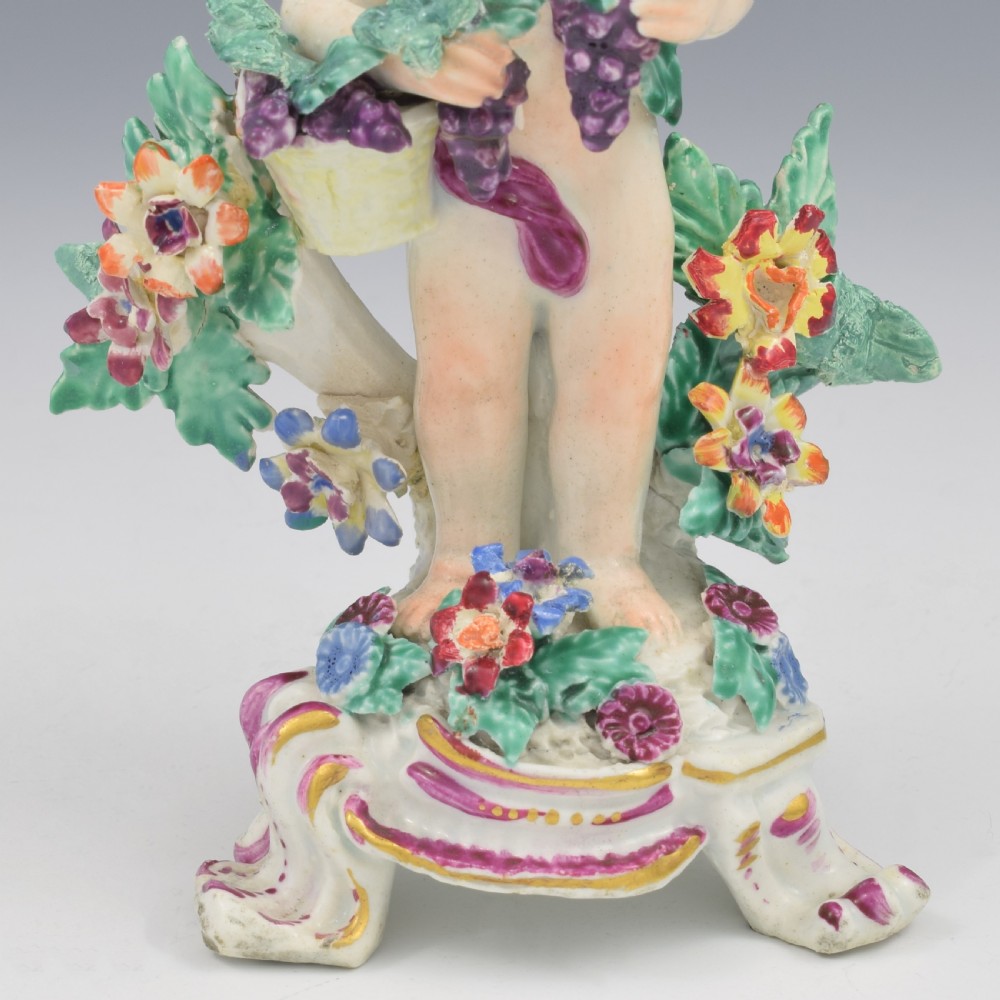 A set of four 18th-century Bow soft-paste porcelain figures representing the seasons, depicting putti on rococo scroll bases with colourful floral bocage. View XXI