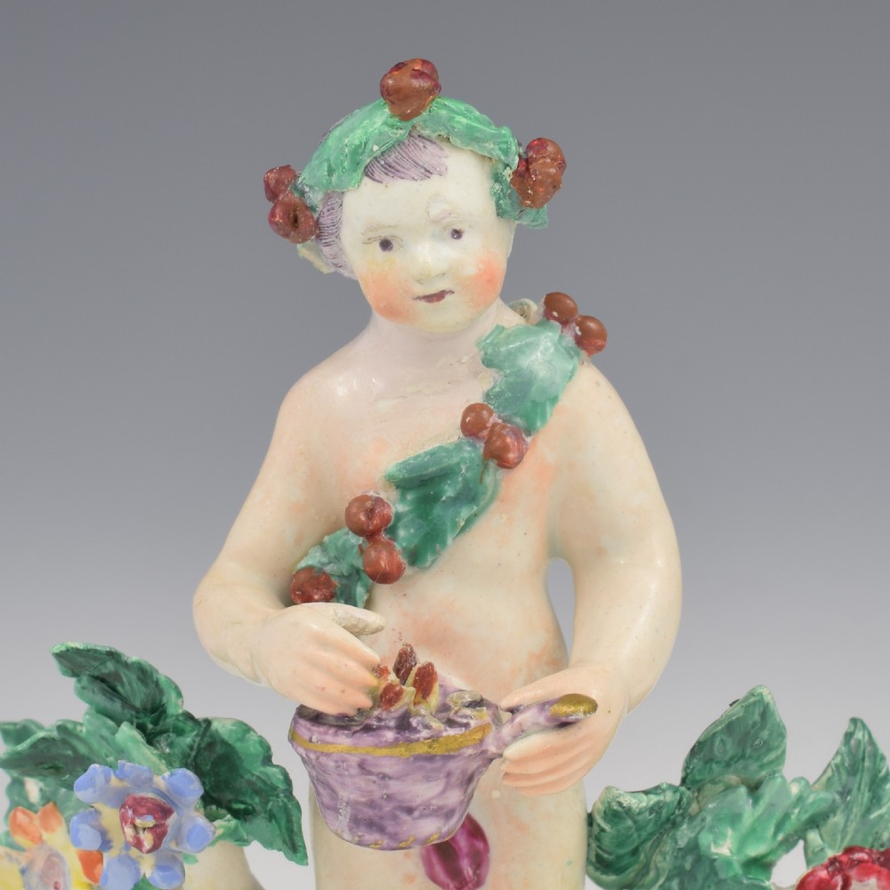 A set of four 18th-century Bow soft-paste porcelain figures representing the seasons, depicting putti on rococo scroll bases with colourful floral bocage. View XXV