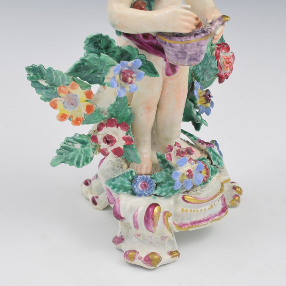 A set of four 18th-century Bow soft-paste porcelain figures representing the seasons, depicting putti on rococo scroll bases with colourful floral bocage. View XXVI