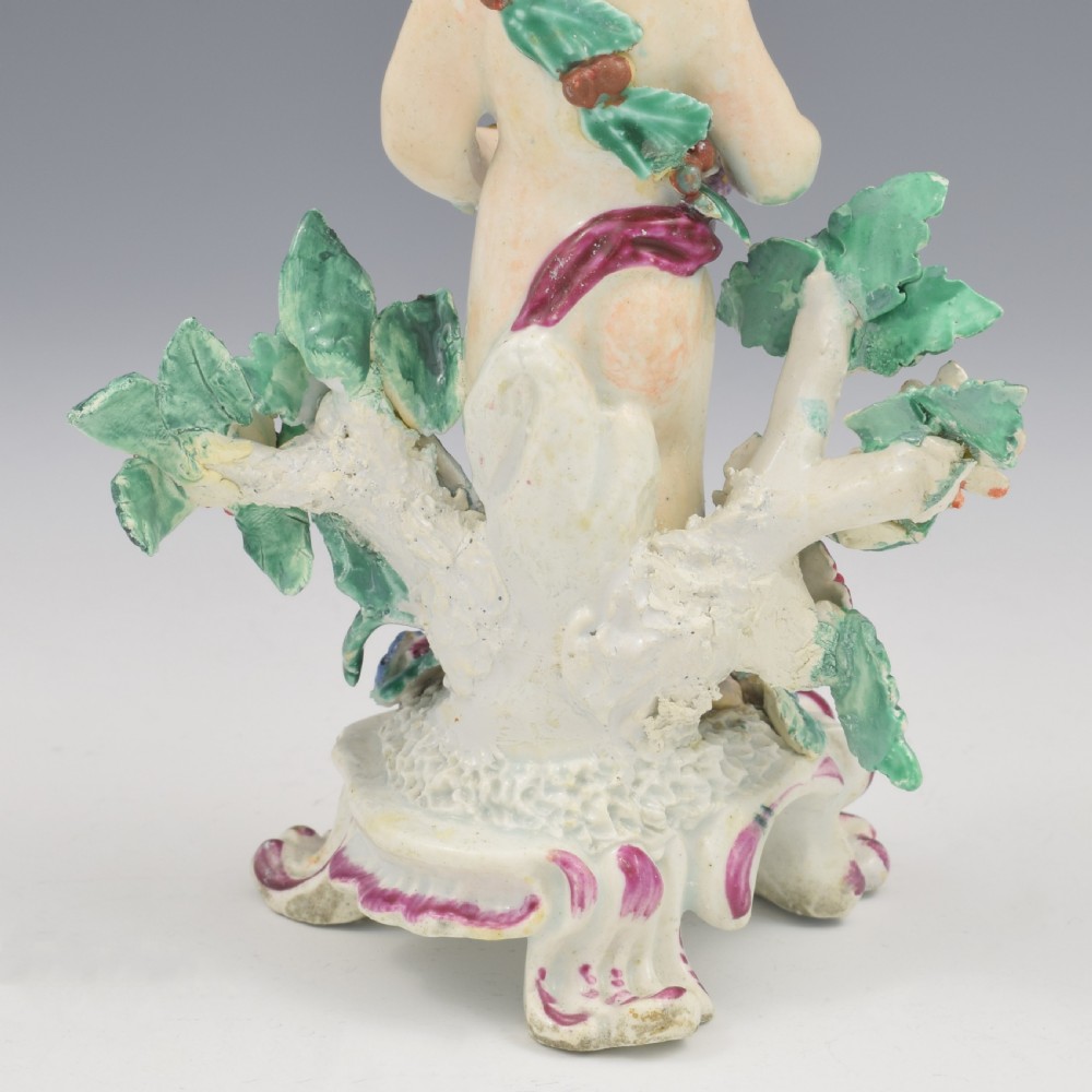 A set of four 18th-century Bow soft-paste porcelain figures representing the seasons, depicting putti on rococo scroll bases with colourful floral bocage. View XXIX