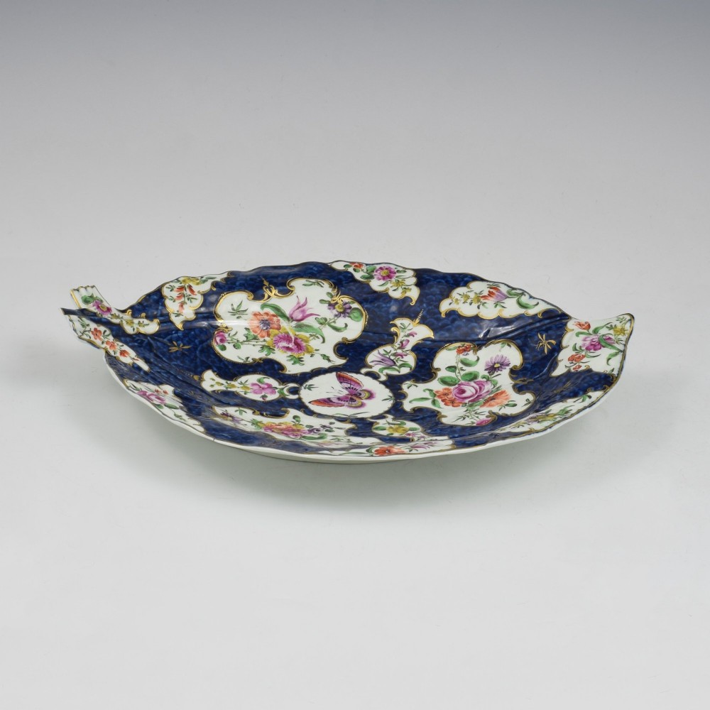 A leaf-shaped eighteenth-century Worcester porcelain dish decorated with a cobalt scale blue ground, gilded rococo reserves, floral sprays, and a central butterfly. View III