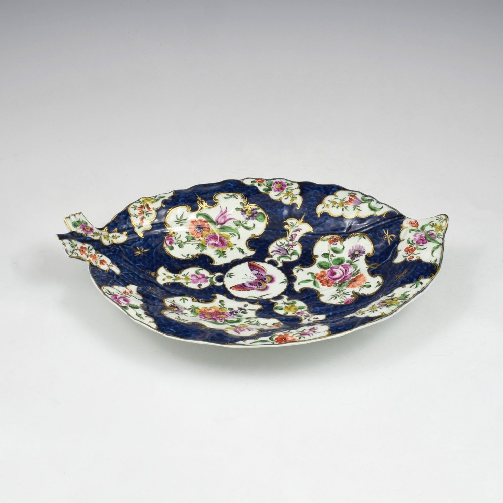 A leaf-shaped eighteenth-century Worcester porcelain dish decorated with a cobalt scale blue ground, gilded rococo reserves, floral sprays, and a central butterfly. View IV