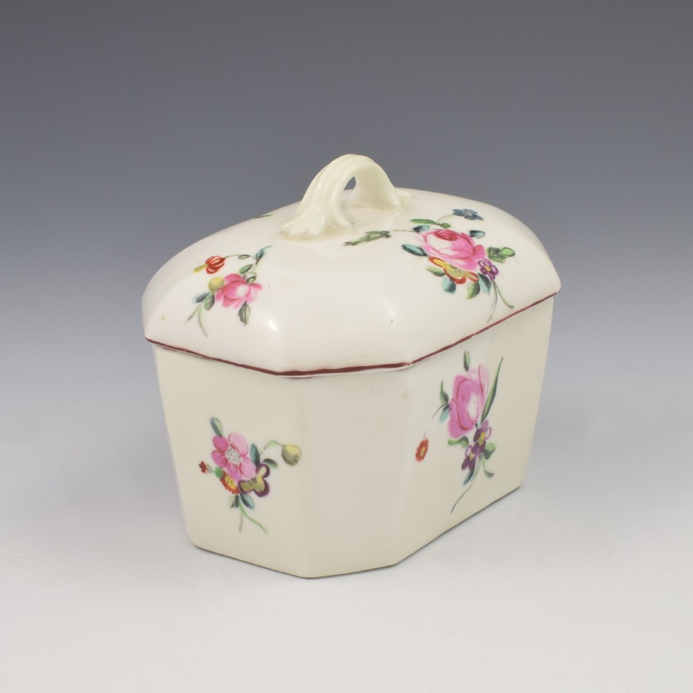 An 18th-century off-white porcelain butter tub with a fitted cover, top handle, and hand-painted floral motifs. View IV