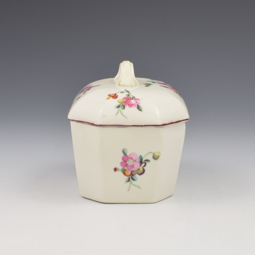 An 18th-century off-white porcelain butter tub with a fitted cover, top handle, and hand-painted floral motifs. View V
