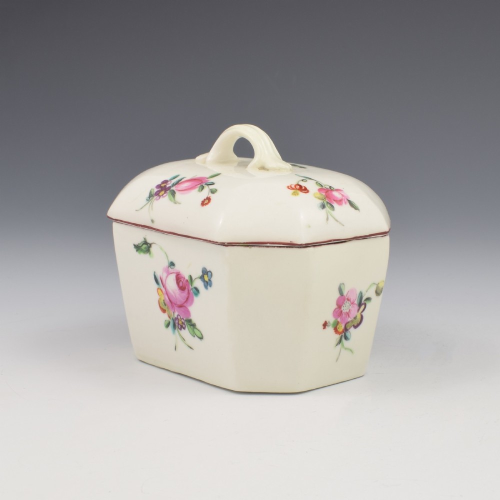 An 18th-century off-white porcelain butter tub with a fitted cover, top handle, and hand-painted floral motifs. View VI