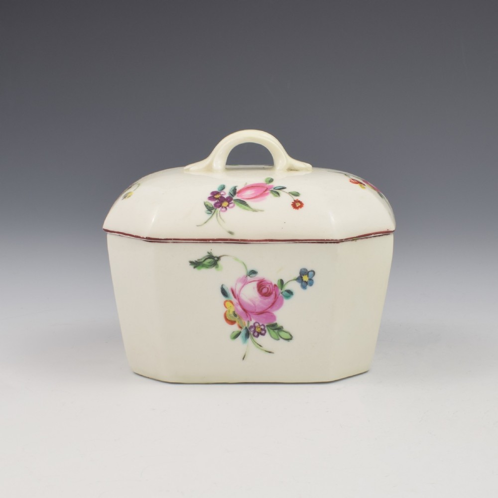 An 18th-century off-white porcelain butter tub with a fitted cover, top handle, and hand-painted floral motifs. View VII