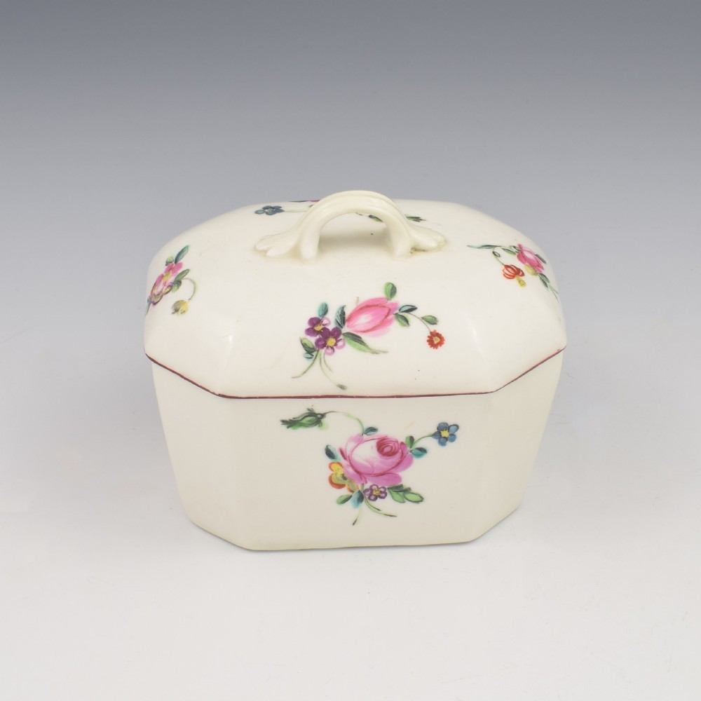An 18th-century off-white porcelain butter tub with a fitted cover, top handle, and hand-painted floral motifs. View VIII