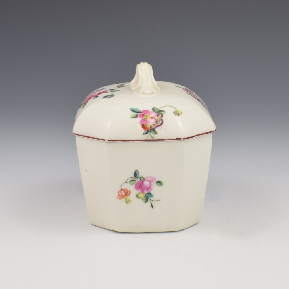 An 18th-century off-white porcelain butter tub with a fitted cover, top handle, and hand-painted floral motifs. View X
