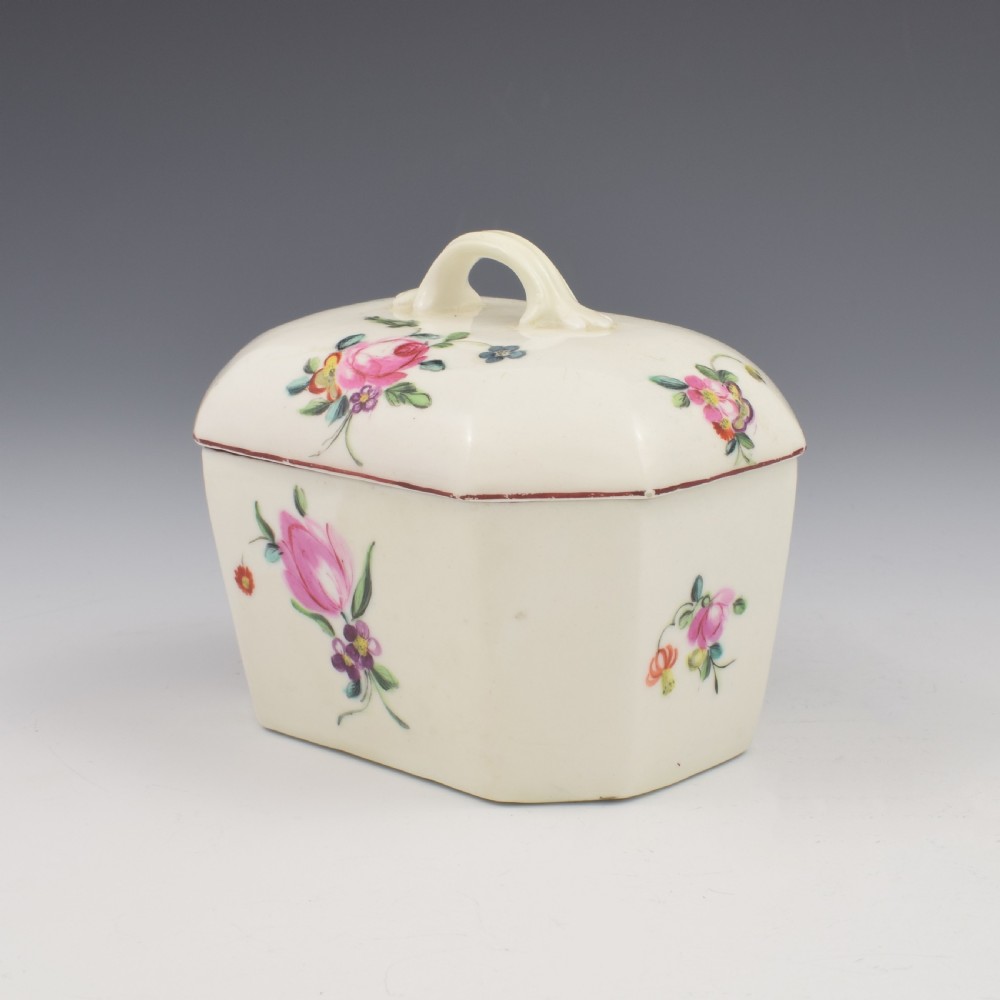 An 18th-century off-white porcelain butter tub with a fitted cover, top handle, and hand-painted floral motifs. View XI