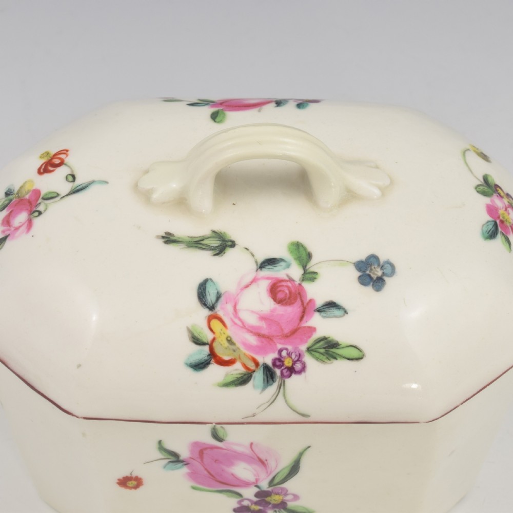 An 18th-century off-white porcelain butter tub with a fitted cover, top handle, and hand-painted floral motifs. View XII