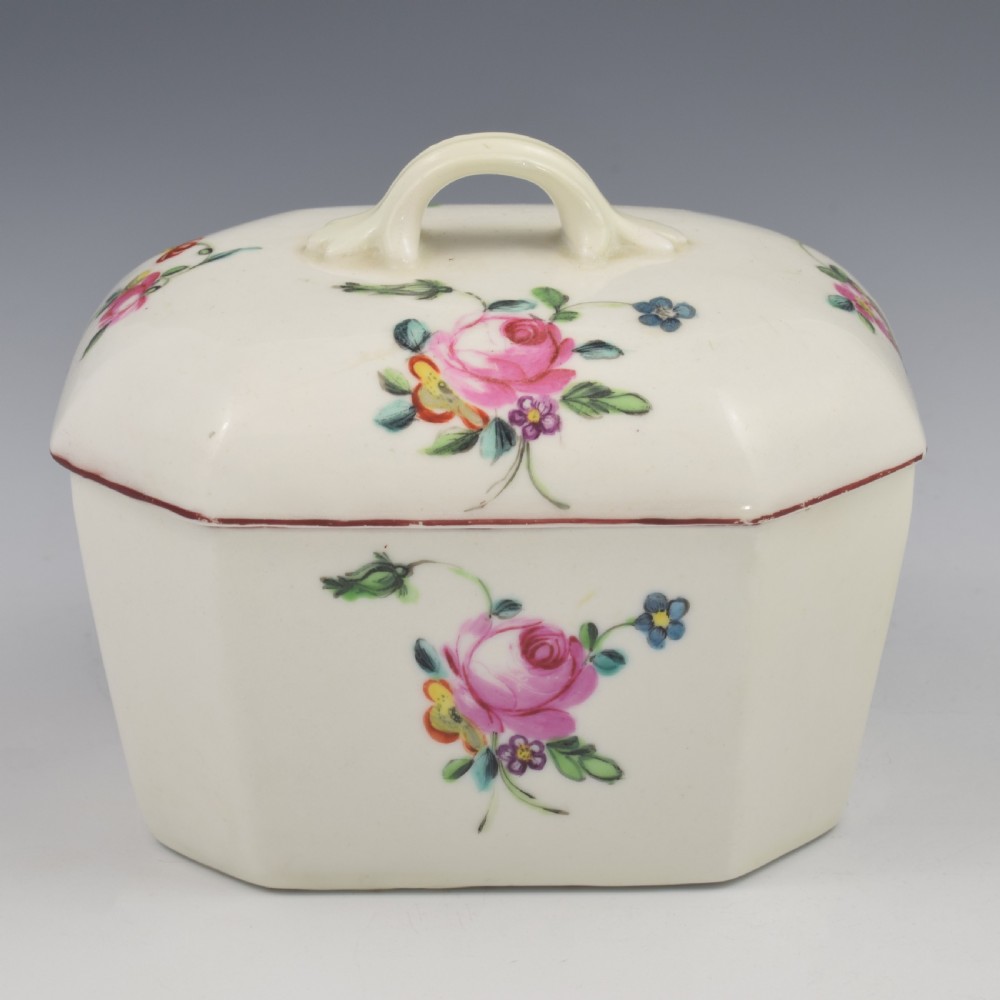 An 18th-century off-white porcelain butter tub with a fitted cover, top handle, and hand-painted floral motifs. View XV
