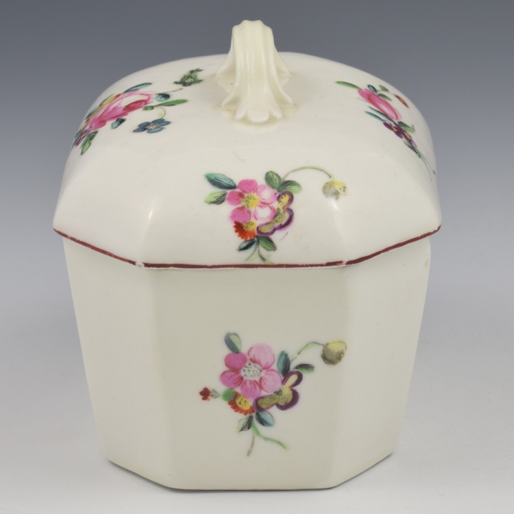 An 18th-century off-white porcelain butter tub with a fitted cover, top handle, and hand-painted floral motifs. View XVI