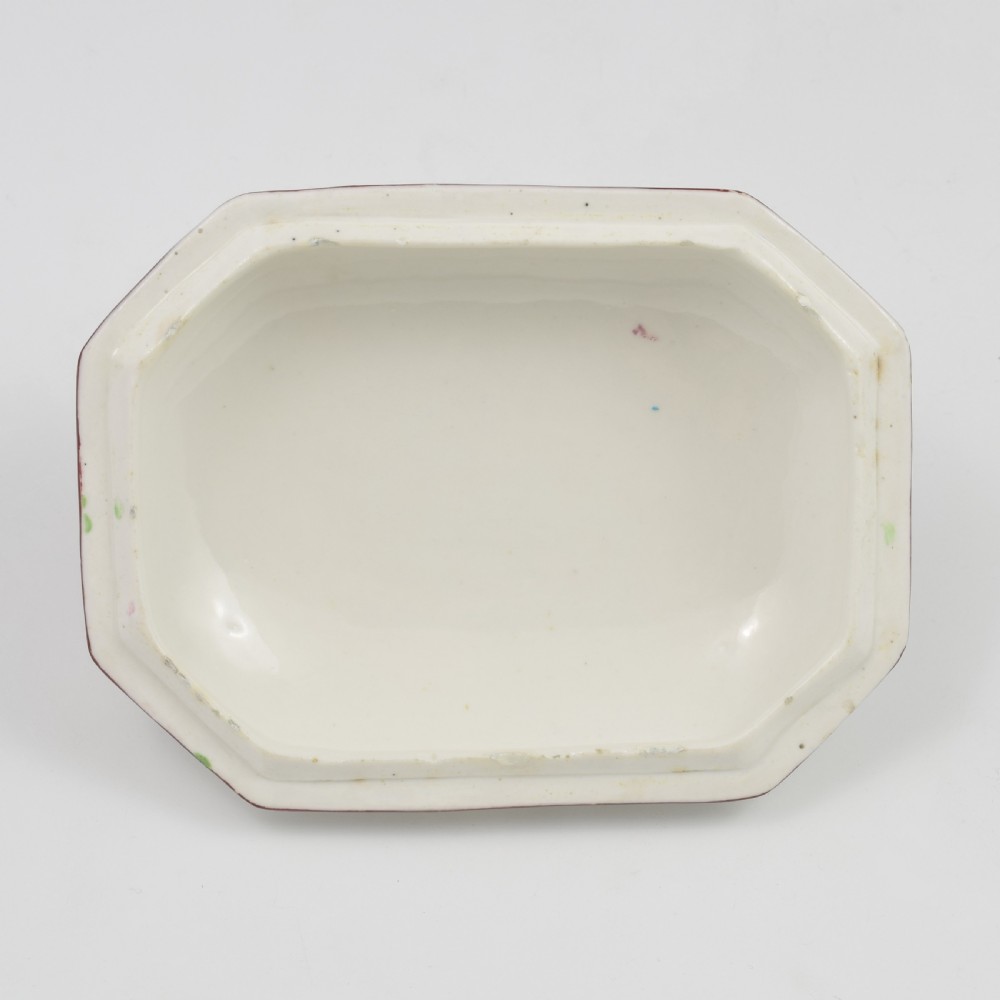 An 18th-century off-white porcelain butter tub with a fitted cover, top handle, and hand-painted floral motifs. View XVIII