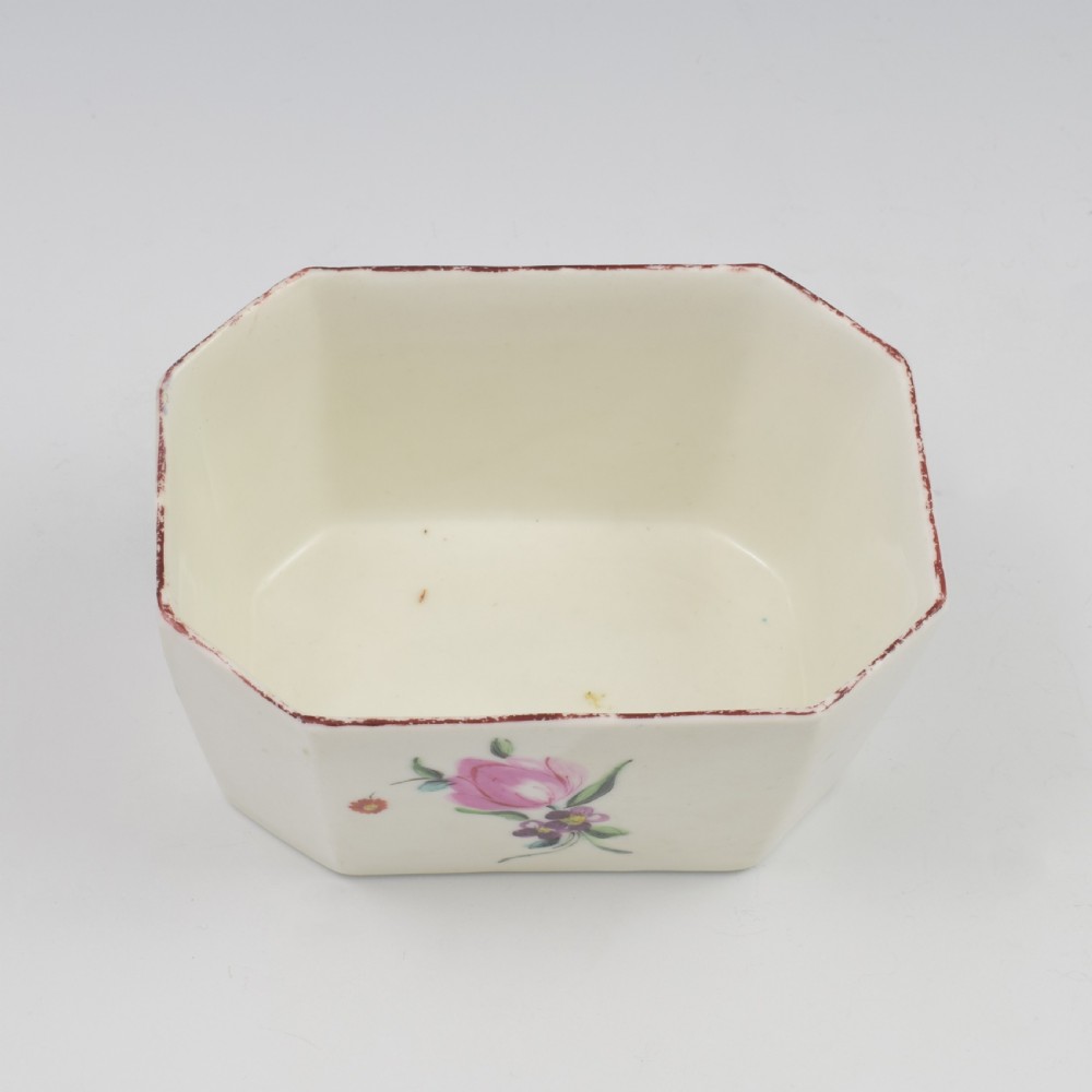An 18th-century off-white porcelain butter tub with a fitted cover, top handle, and hand-painted floral motifs. View XIX