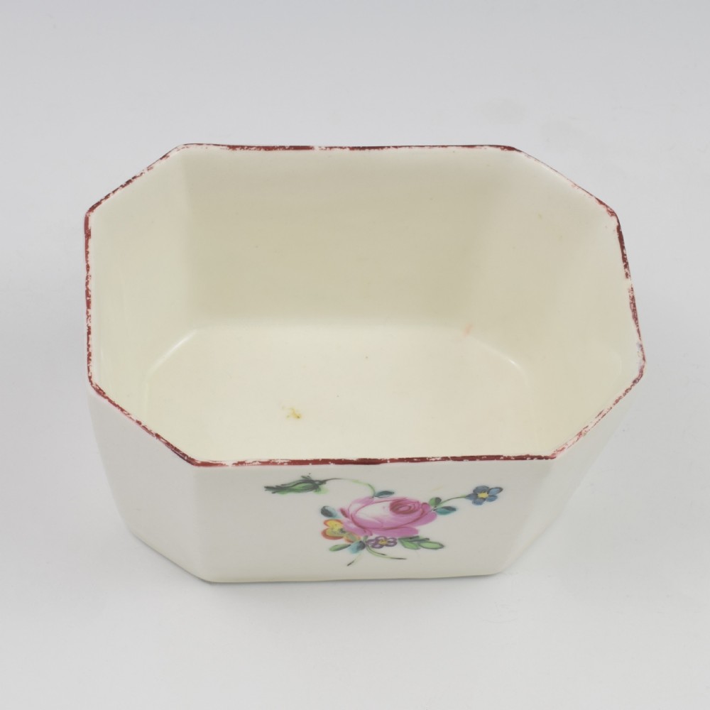An 18th-century off-white porcelain butter tub with a fitted cover, top handle, and hand-painted floral motifs. View XX