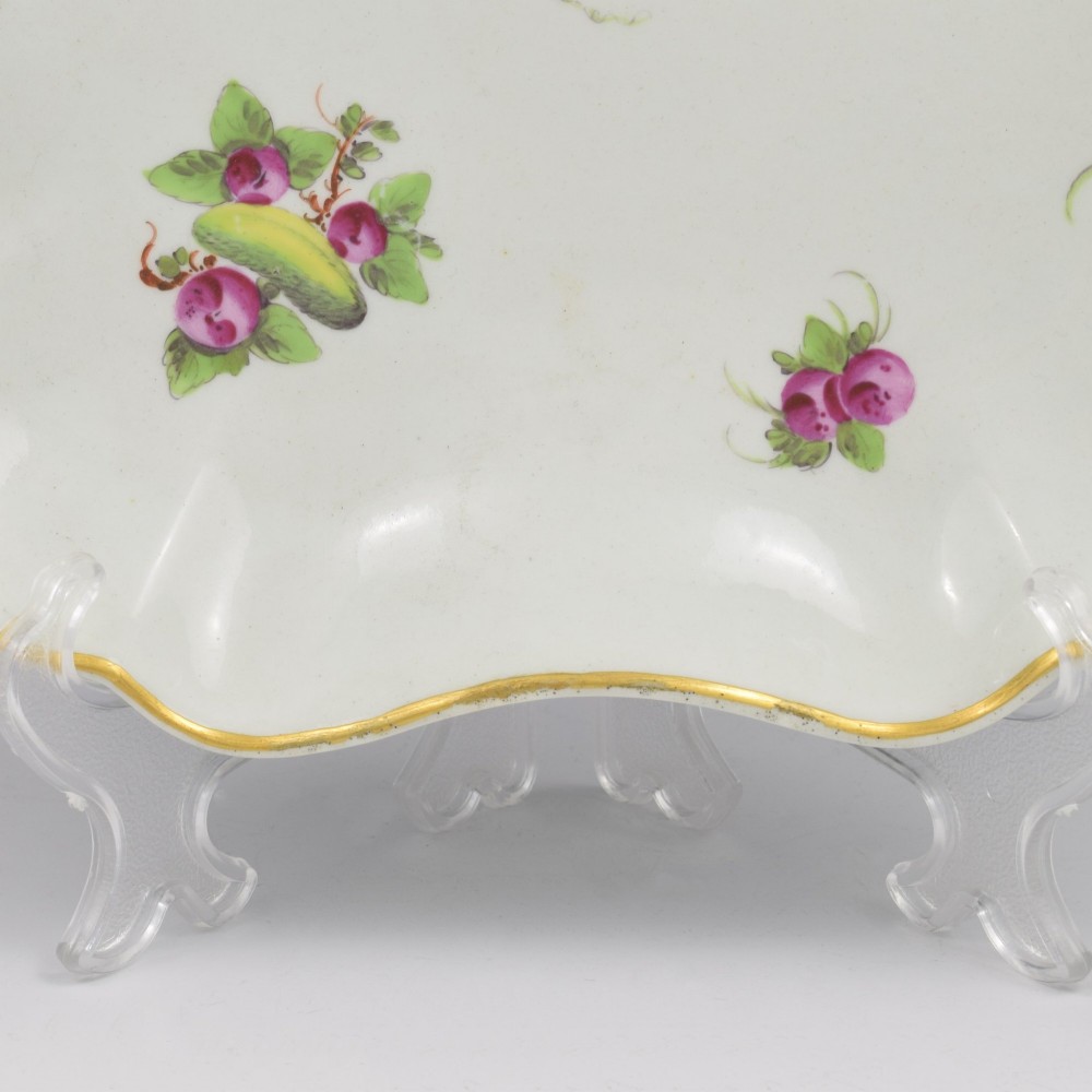 An eighteenth-century square lobed soft-paste porcelain dessert dish featuring hand-painted fruit sprays and a gilded rim. View III