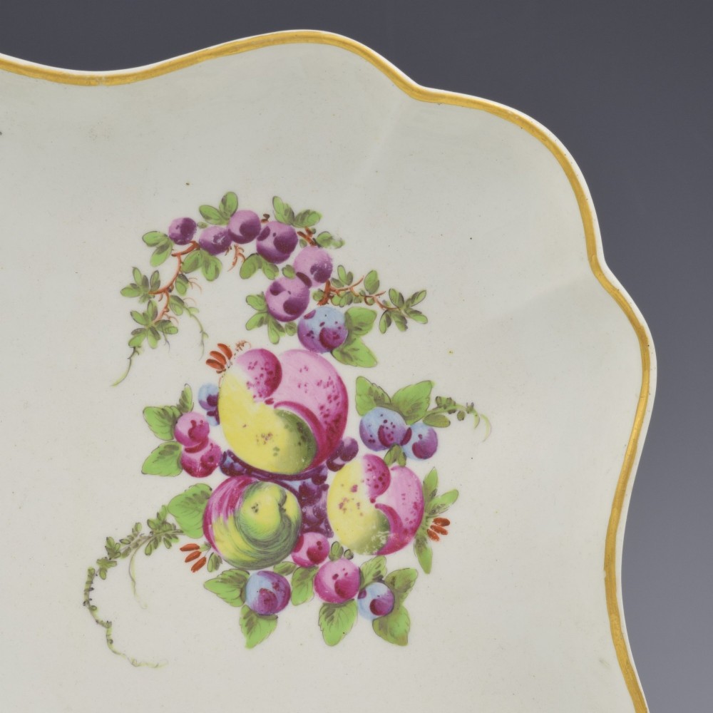 An eighteenth-century square lobed soft-paste porcelain dessert dish featuring hand-painted fruit sprays and a gilded rim. View IV