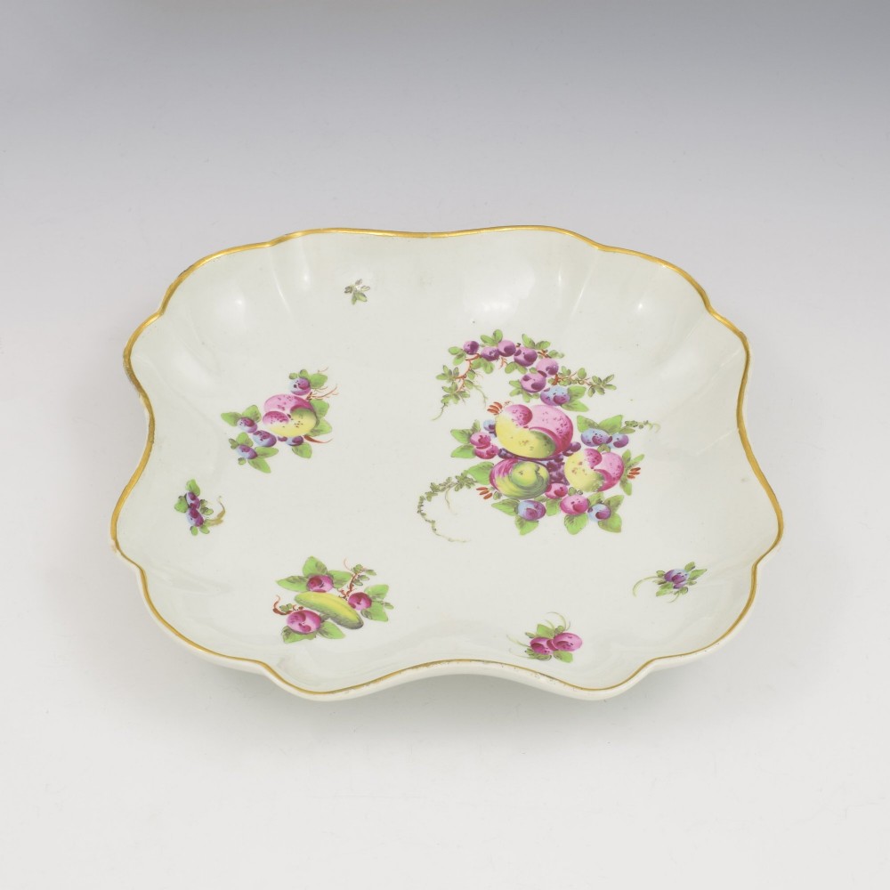 An eighteenth-century square lobed soft-paste porcelain dessert dish featuring hand-painted fruit sprays and a gilded rim. View VII