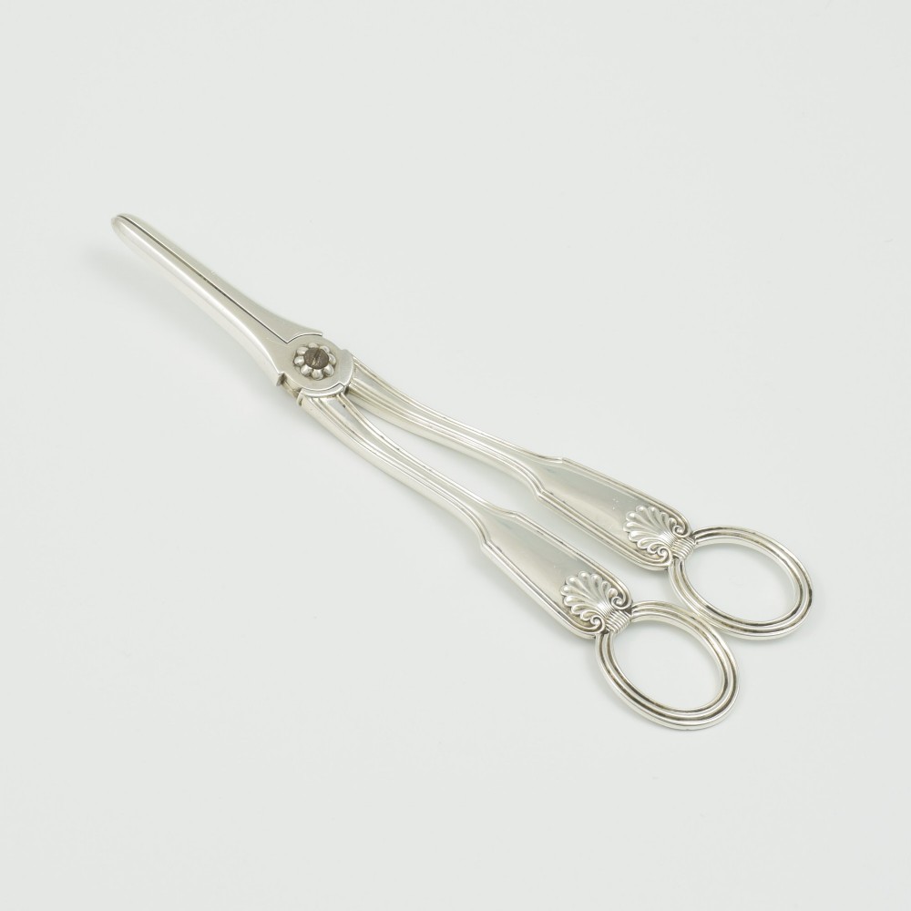 A pair of late Victorian sterling silver grape scissors featuring shell motifs near the oval finger loops and molded handles. View II
