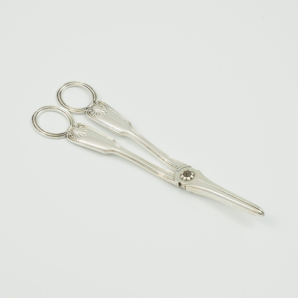 A pair of late Victorian sterling silver grape scissors featuring shell motifs near the oval finger loops and molded handles. View IV