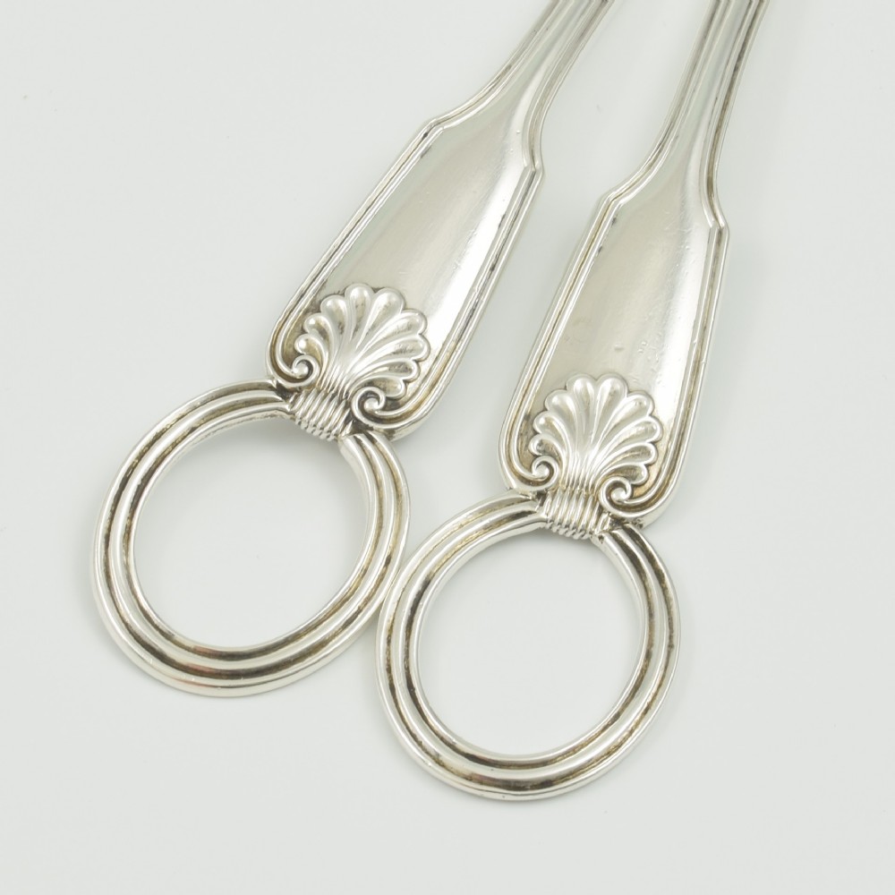 A pair of late Victorian sterling silver grape scissors featuring shell motifs near the oval finger loops and molded handles. View V
