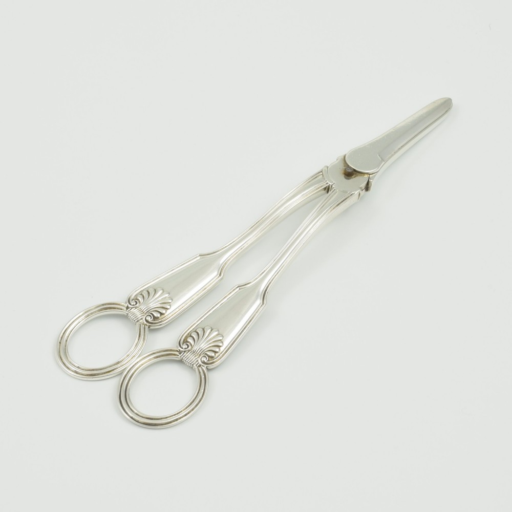 A pair of late Victorian sterling silver grape scissors featuring shell motifs near the oval finger loops and molded handles. View VI
