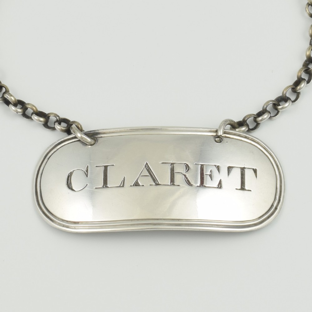 A Georgian sterling silver oblong decanter label engraved with the word CLARET and suspended from a fine silver chain. View II