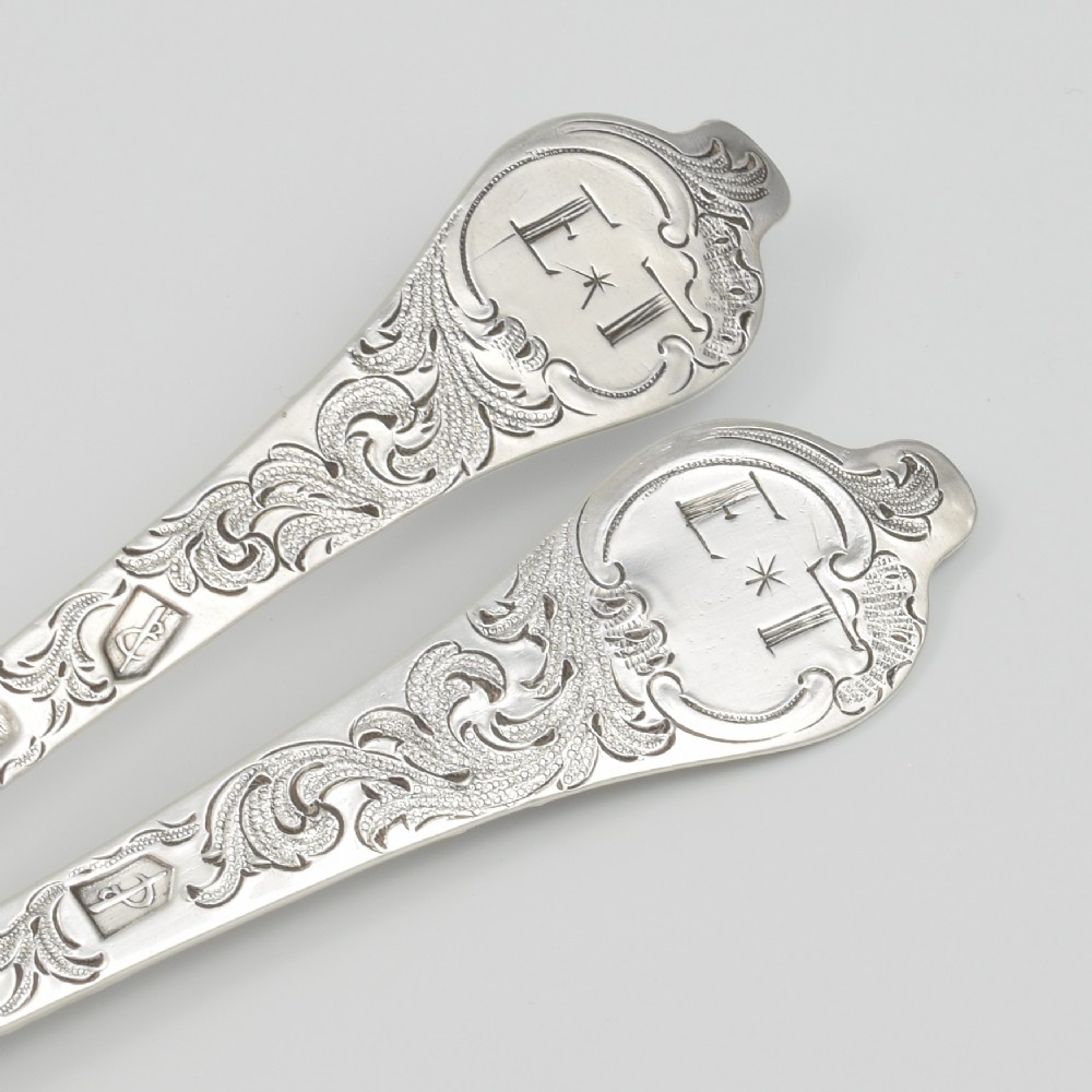 A pair of William III sterling silver dognose spoons featuring chased floral stems and gilded, scalloped bowls. View VII