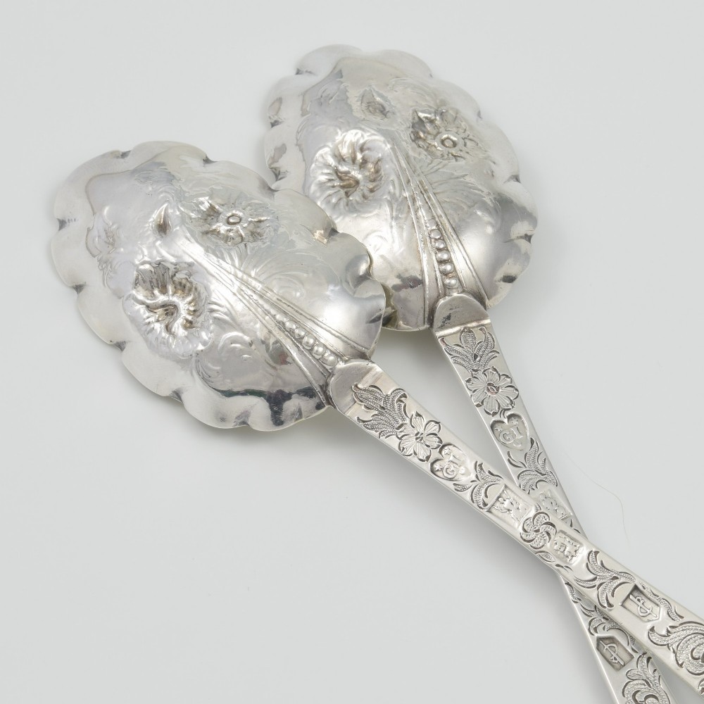 A pair of William III sterling silver dognose spoons featuring chased floral stems and gilded, scalloped bowls. View VIII