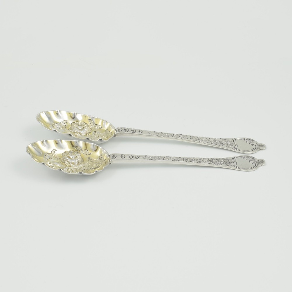 A pair of William III sterling silver dognose spoons featuring chased floral stems and gilded, scalloped bowls. View XI