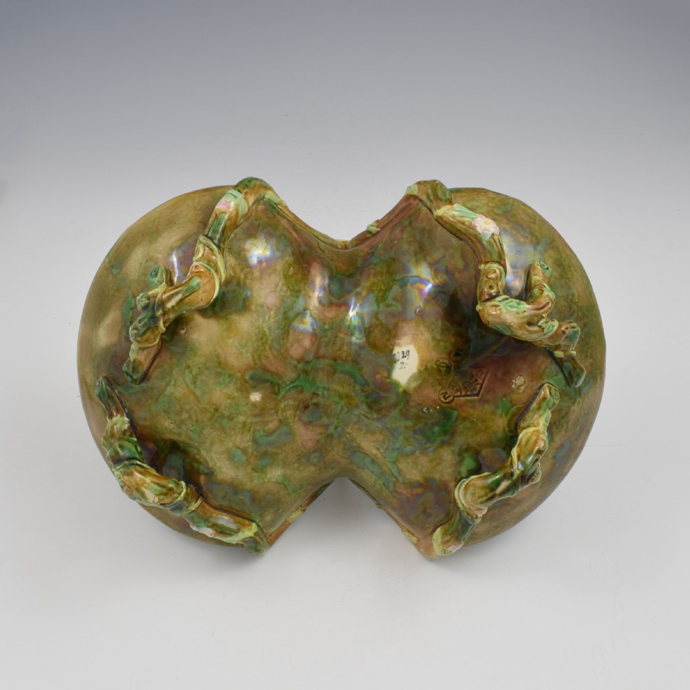 A Victorian George Jones majolica strawberry basket featuring double compartments decorated with relief leaves, pink blossoms, and an overarching branch handle in green, brown, and turquoise glazes. View IX