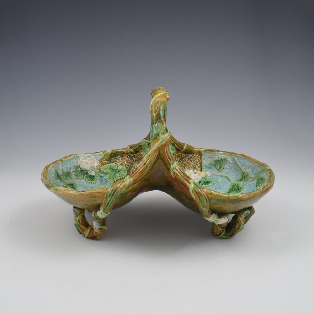 A Victorian George Jones majolica strawberry basket featuring double compartments decorated with relief leaves, pink blossoms, and an overarching branch handle in green, brown, and turquoise glazes. View XIII