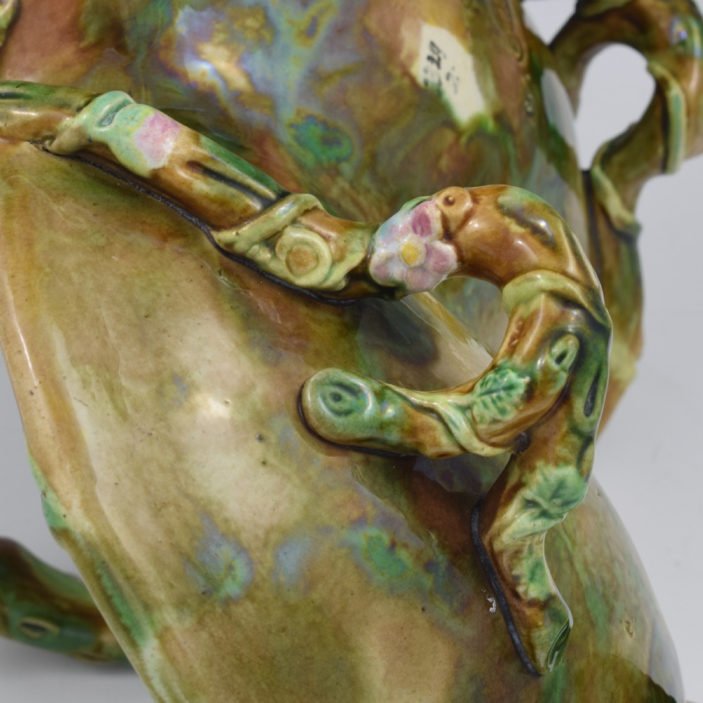 A Victorian George Jones majolica strawberry basket featuring double compartments decorated with relief leaves, pink blossoms, and an overarching branch handle in green, brown, and turquoise glazes. View XV