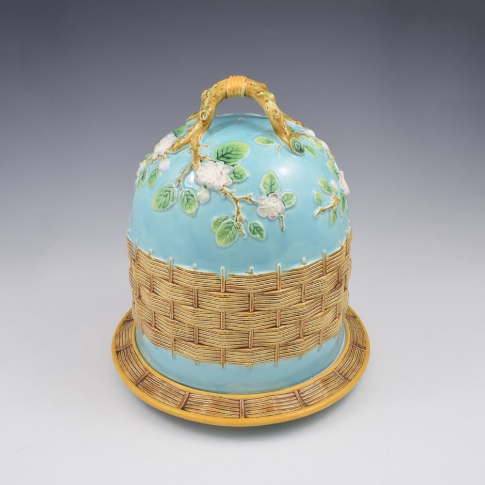 A Victorian George Jones majolica cheese bell and stand featuring a turquoise dome decorated with relief apple blossoms, a woven basketweave lower band, and a twig-form handle. View III