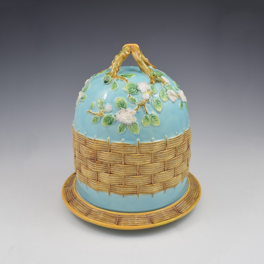 A Victorian George Jones majolica cheese bell and stand featuring a turquoise dome decorated with relief apple blossoms, a woven basketweave lower band, and a twig-form handle. View IV