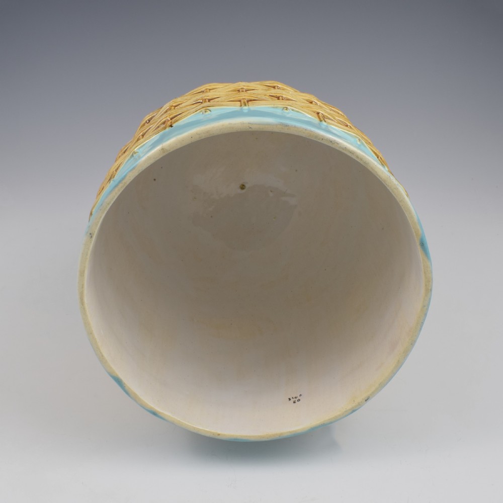 A Victorian George Jones majolica cheese bell and stand featuring a turquoise dome decorated with relief apple blossoms, a woven basketweave lower band, and a twig-form handle. View XII
