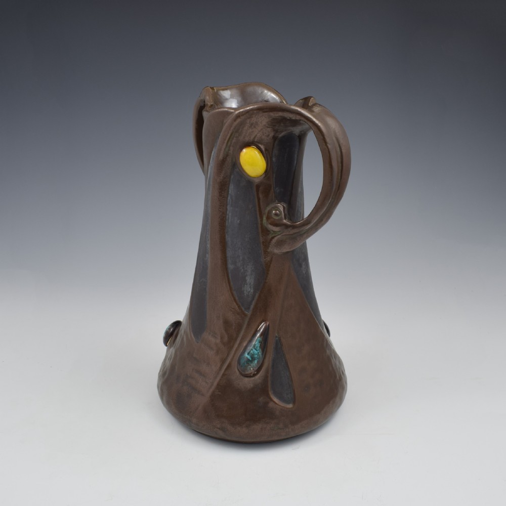An Art Nouveau brown ceramic vase featuring a metallic copper effect surface, organic twin handles, flared rim, and inset colourful glazed cabochons. View II